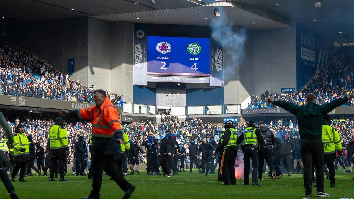 Rangers- und Celtic-Fans auf dem Spielfeld im Ibrox Park
