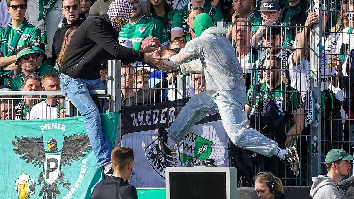 Ein Münster-Fan klettert zurück in den Block