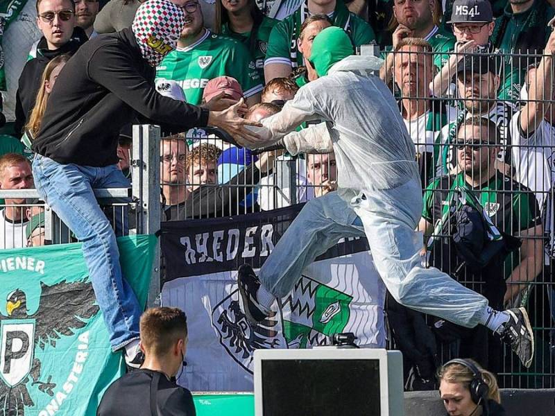 Ein Münster-Fan klettert zurück in den Block